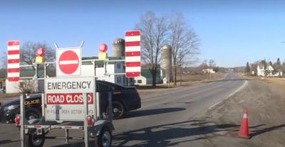 A police car behind an emergency closed sign