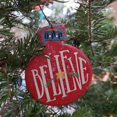 OPP believe ornament on a christmas tree