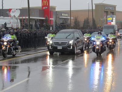 A picture of a hurse being police escorted